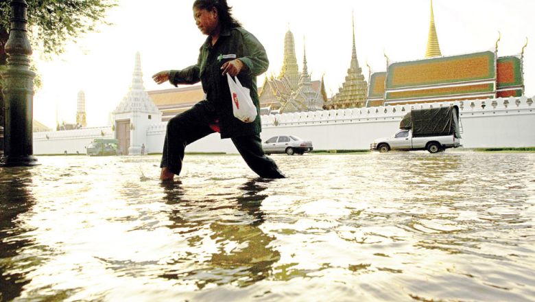 A woman walks through floodwaters in front of the Grand Palace near the Chao Praya river in Bangkok on October 28, 2011. AFP